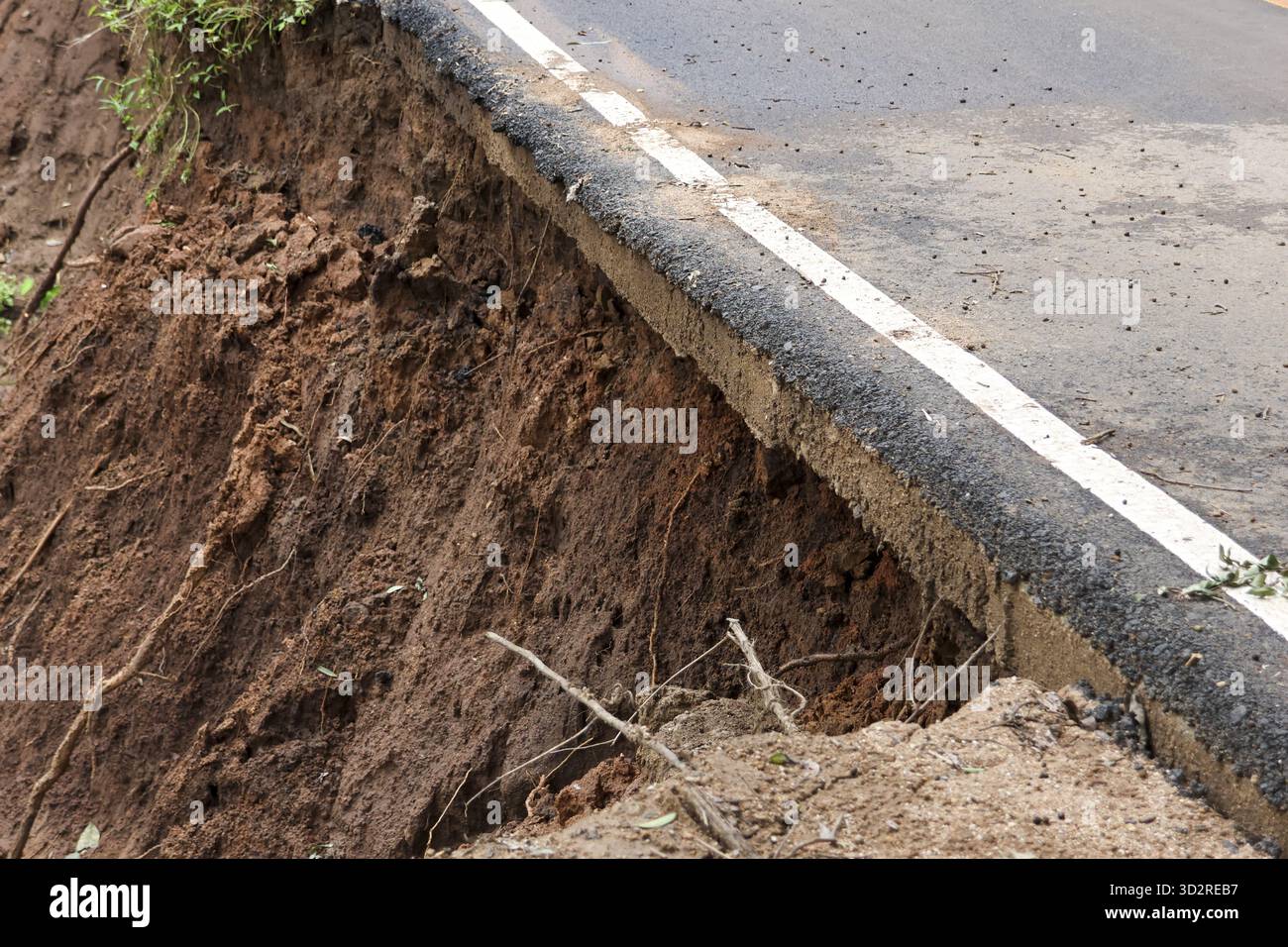 Dangerous landslide causing soil erosion and road damage. asphalt ...