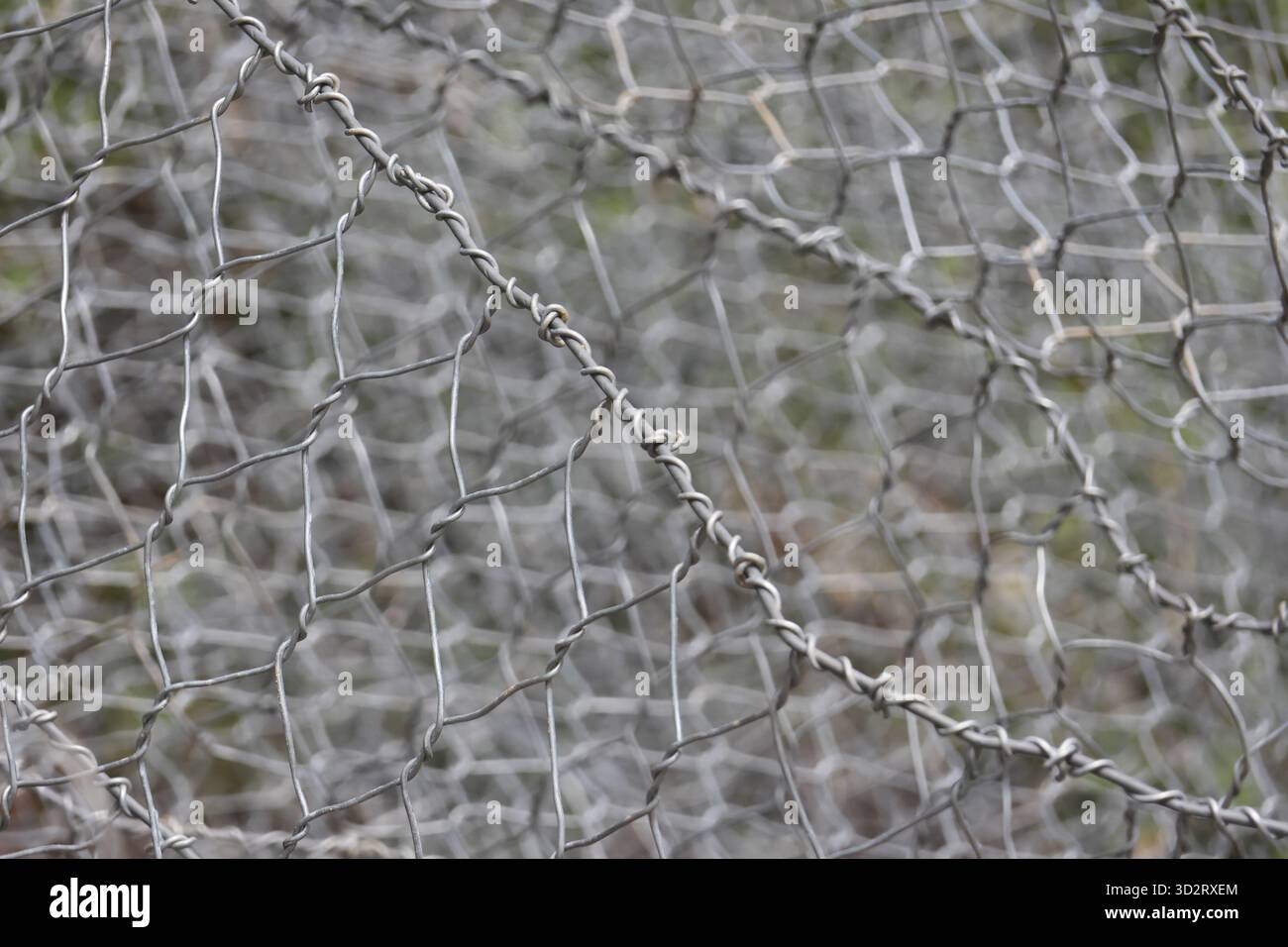 Wire mesh metal fence forms protective pattern, texture, gray silver, strong Stock Photo