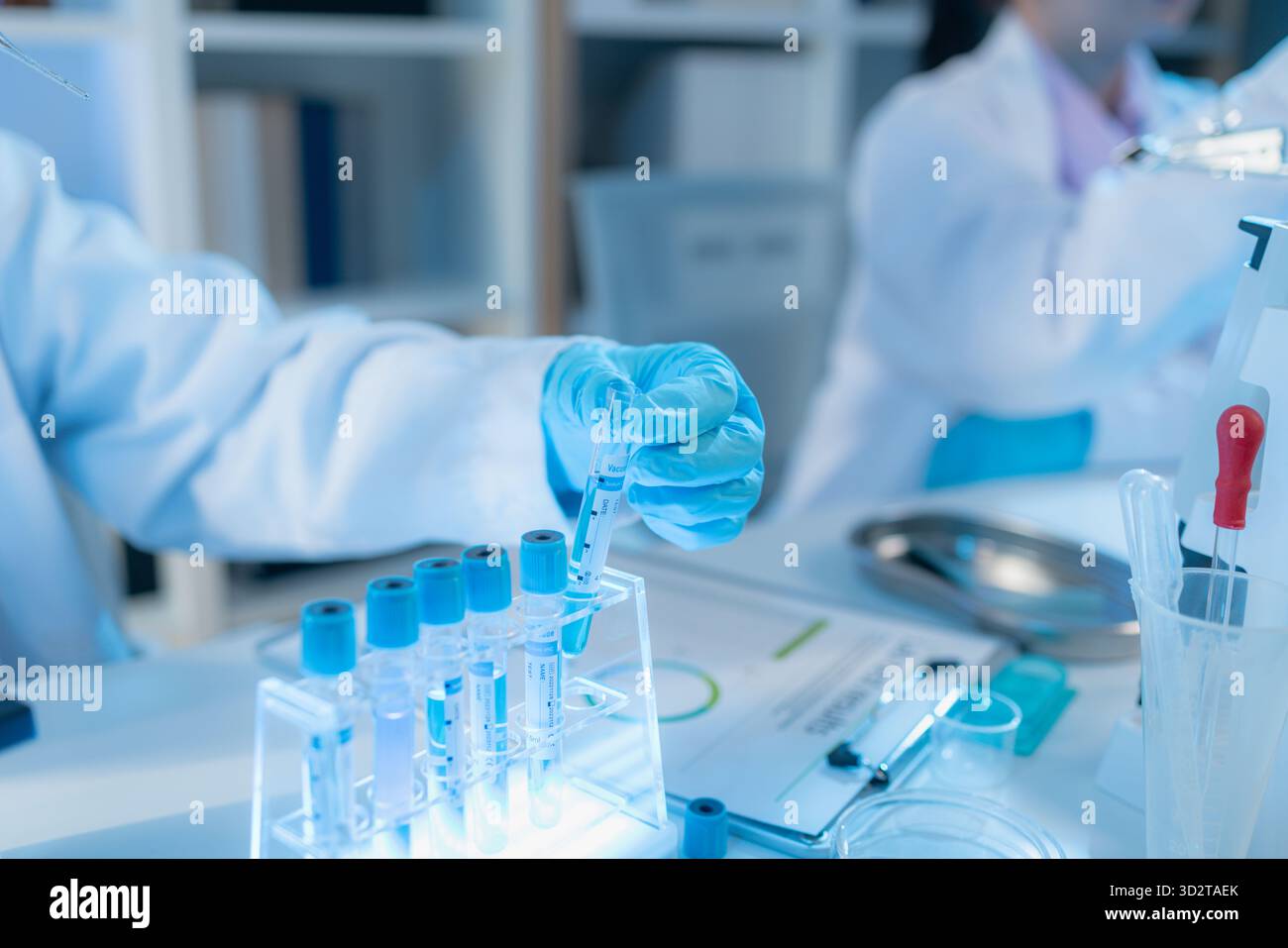 Two female scientists in white lab coats working together in a bright ...