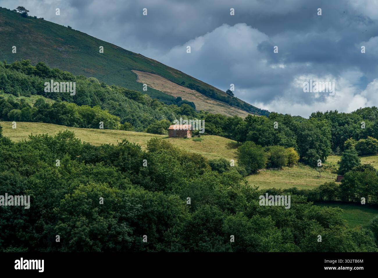 Scenic View of a Small Traditional Stone Farmhouse Surrounded by Lush Greenery and Forest in the Mountainous Baztan Valley, Navarra, Spain Stock Photo