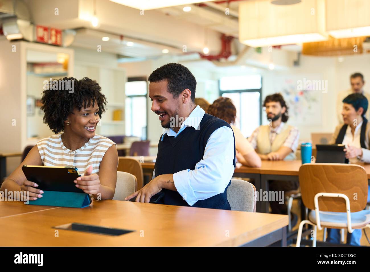 Colleagues collaborating on tablet in modern office Stock Photo