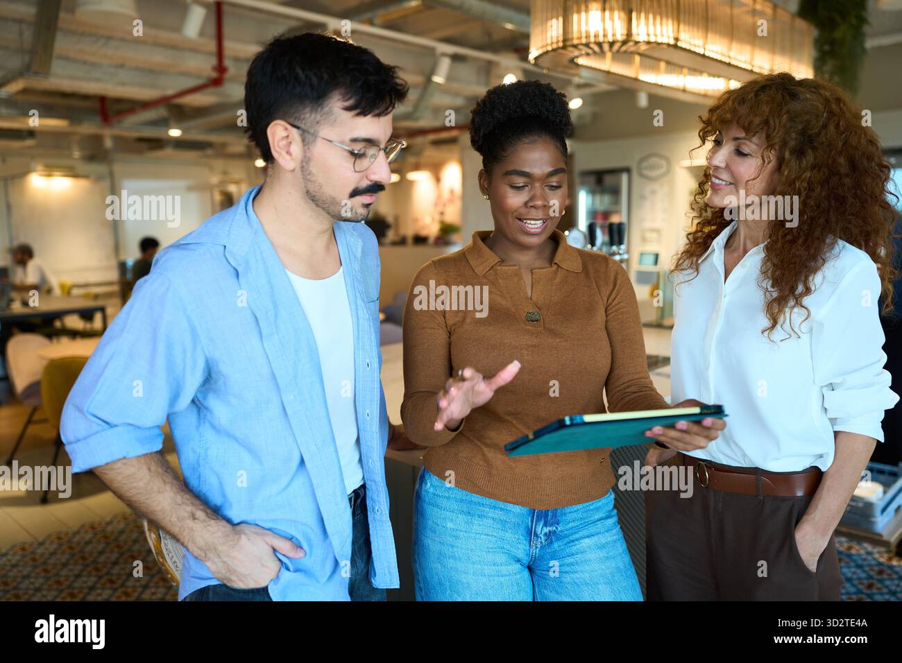 Diverse business team discussing project using tablet Stock Photo