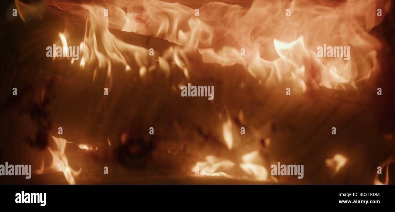 Flames engulf wood in a vivid display of heat and swirling motion Stock Photo