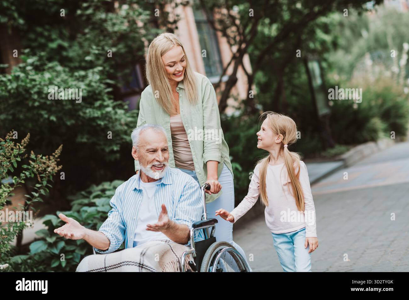 A heartwarming family walk scene with grandpa in a wheelchair