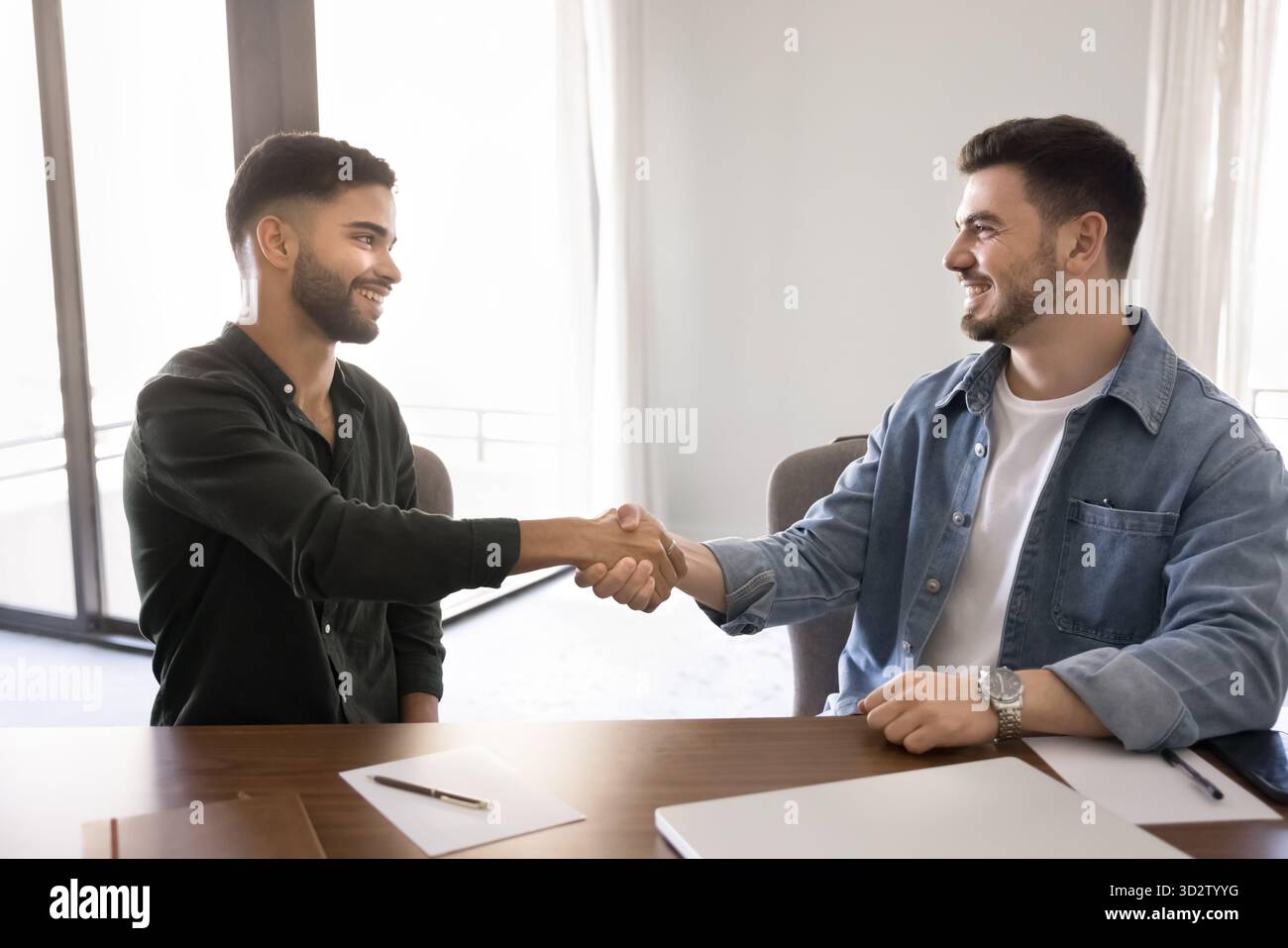 Two men shaking hands after business agreement Stock Photo