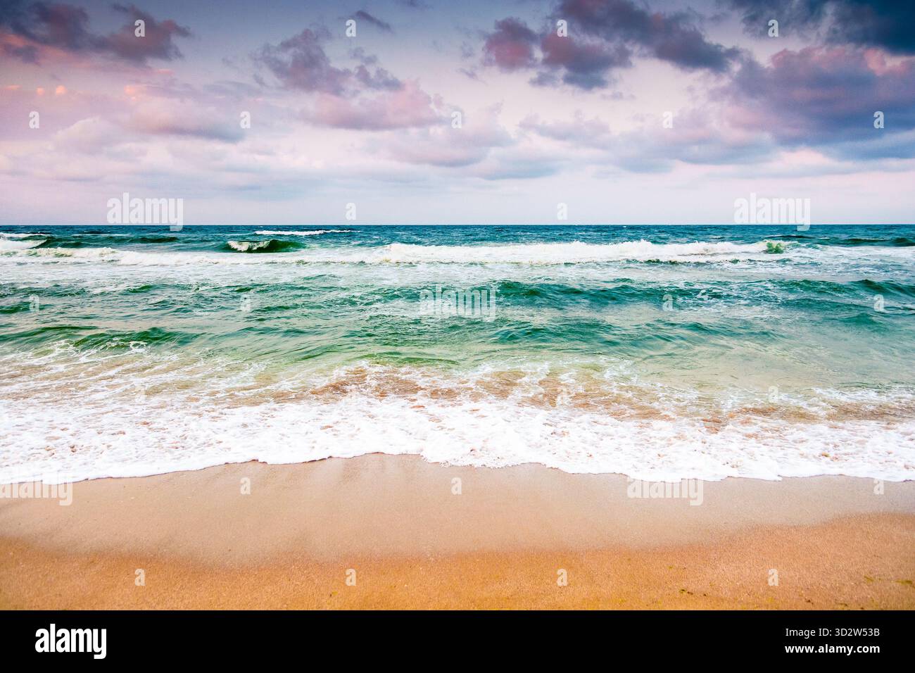 black sea waves crashing sandy beach of bulgaria. summer vacation on a windy weather day under dark cloudy sky. view of dramatic seascape. background Stock Photo