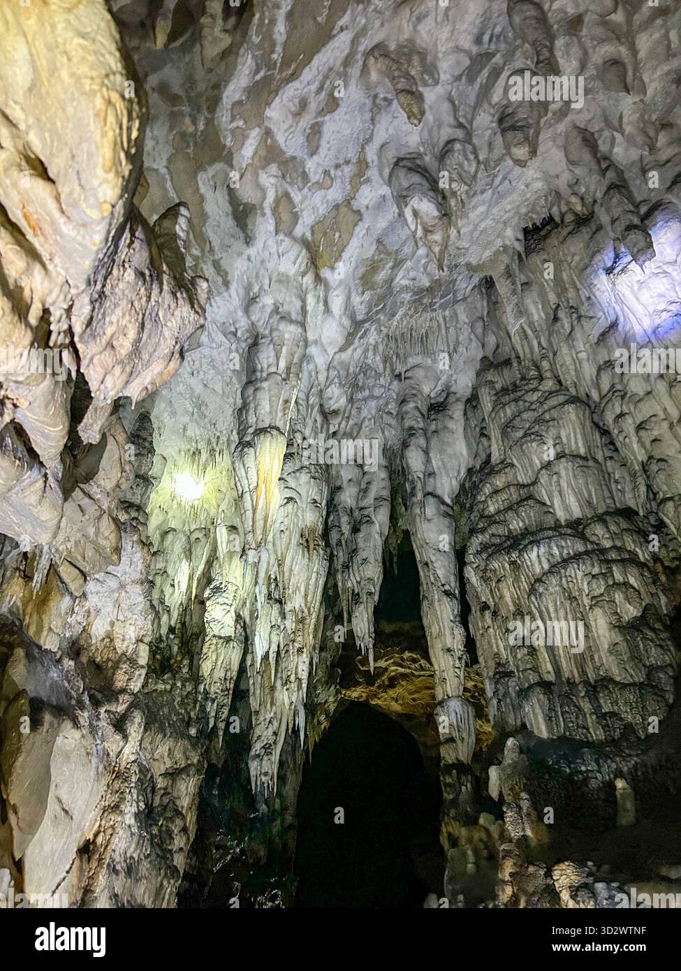 Magnificent view of stalactites hanging from the ceiling of a limestone cave, showcasing natural rock formations shaped over thousands of years. - Smartphone Captured Stock Image