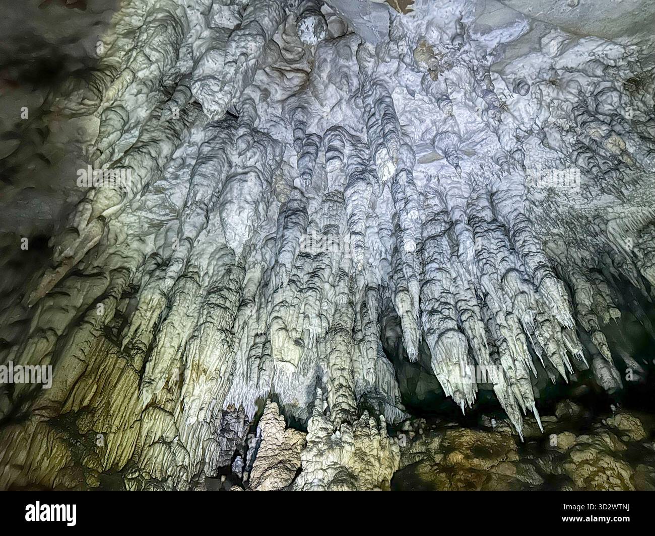 Impressive view of stalactites and rock formations inside the Ice Cave in Uvac Canyon, Serbia, illuminated by artificial light. - Smartphone Captured Stock Image