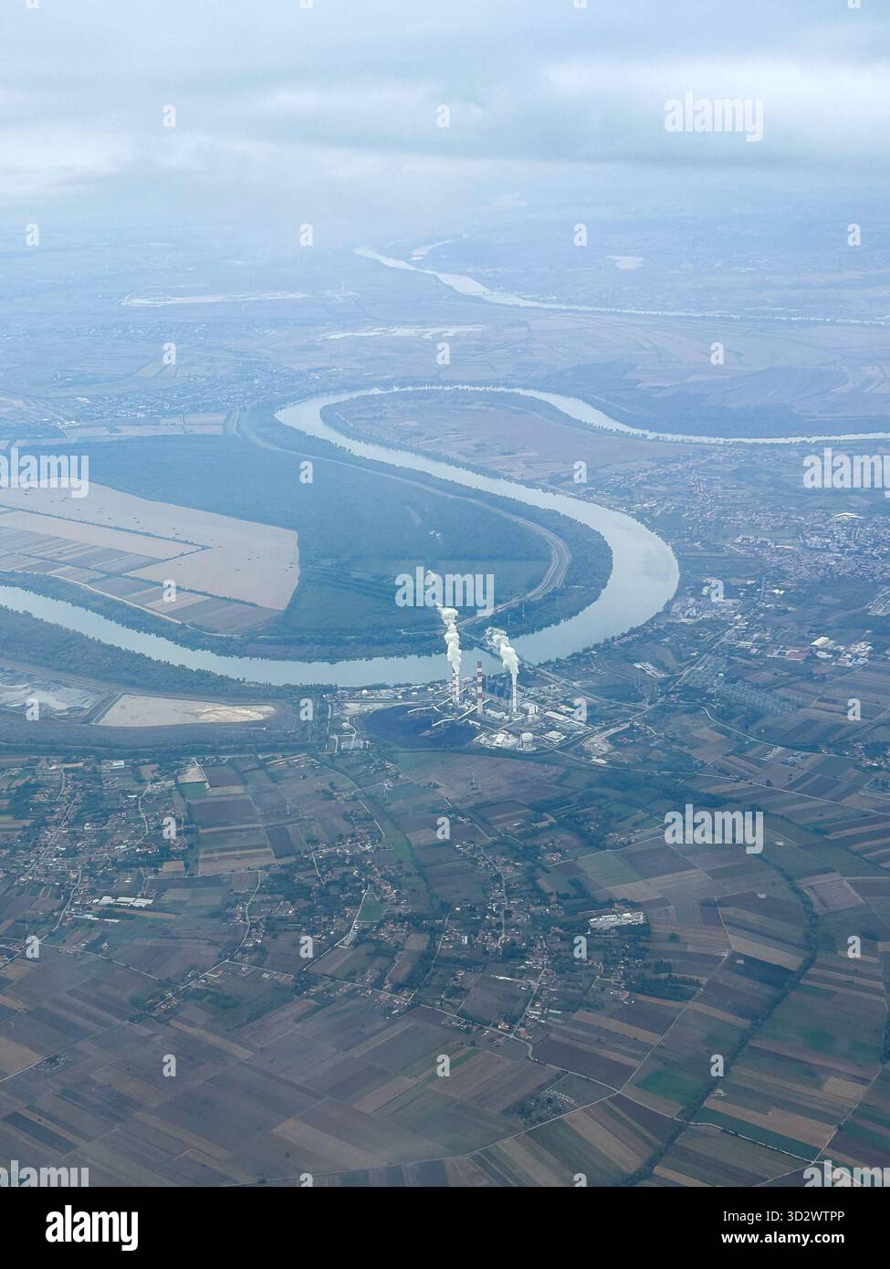 image showing the Nikola Tesla A Thermal Power Plant in Obrenovac, Serbia, with a winding river and farmland, photographed from the air. - Smartphone Captured Stock Image