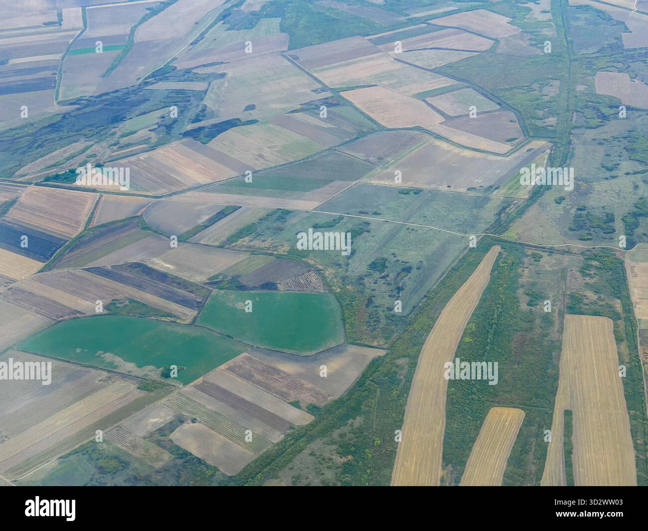 Aerial perspective of agricultural land arranged in geometric patterns, with different field colors and boundaries. - Smartphone Captured Stock Image