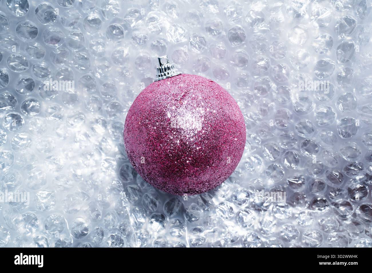 Glittery pink Christmas bauble on bubble wrap Stock Photo