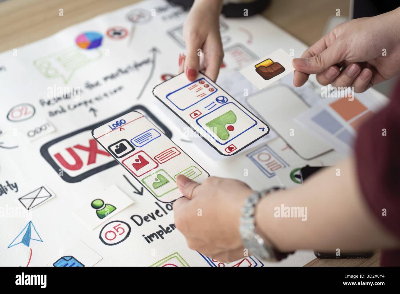 Hands-on collaboration in UX design, focusing on user interface elements and app features with visual aids Stock Photo