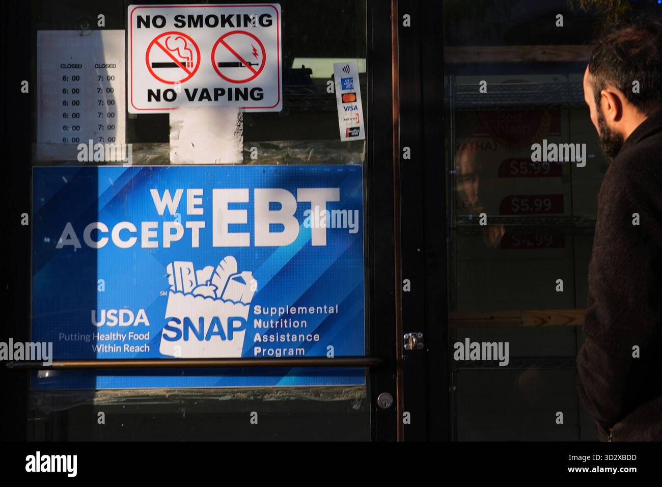 A customer walks into a bakery with a SNAP EBT information sign ...