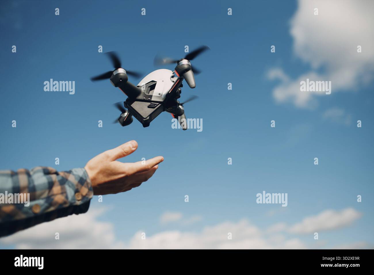 Man pilot Launches quadcopter drone from hand to sky flight Stock Photo
