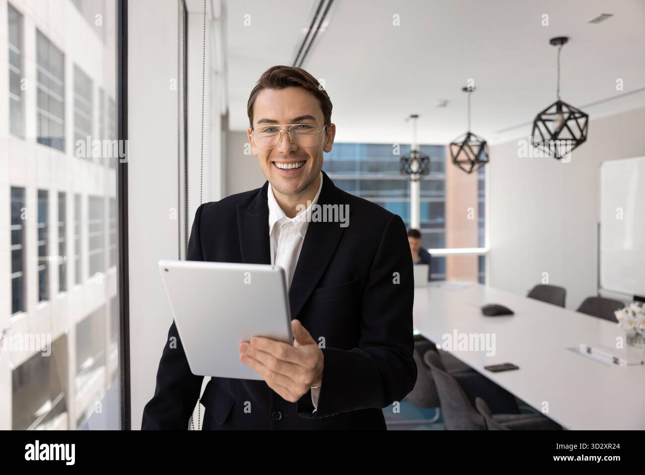 Happy handsome young business professional man using tablet Stock Photo