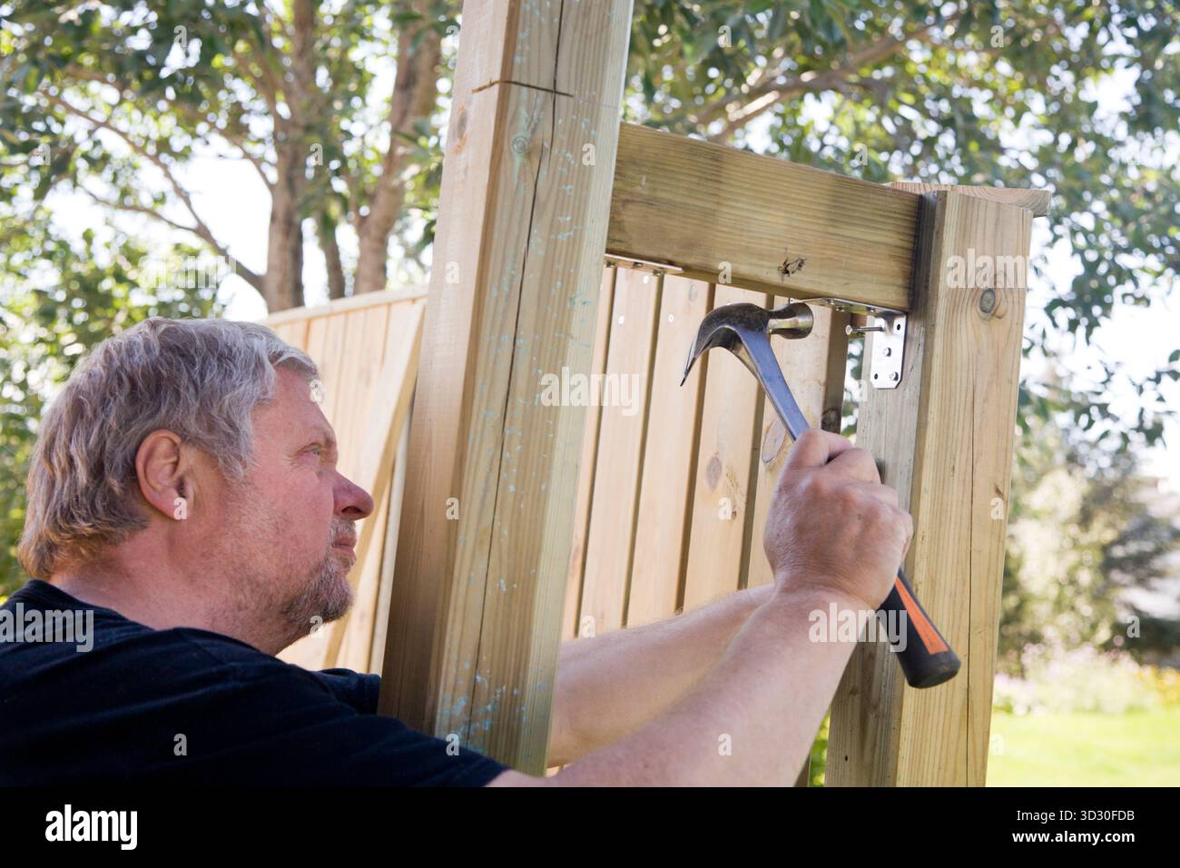 Man Building Things Man building a wooden wall in the garden Stock Photo - Alamy