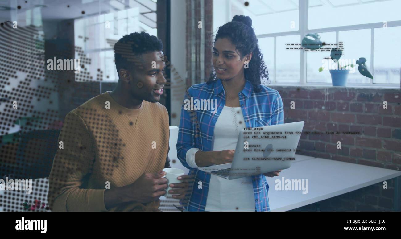Discussing code snippets while software developers viewing laptop at brick office, with coffee mug Stock Photo