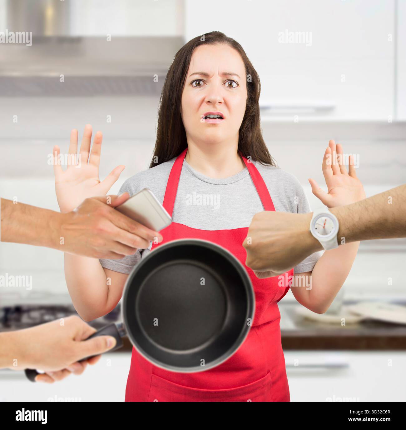 stressed housewife with multi-tasking at the kitchen of her home Stock Photo