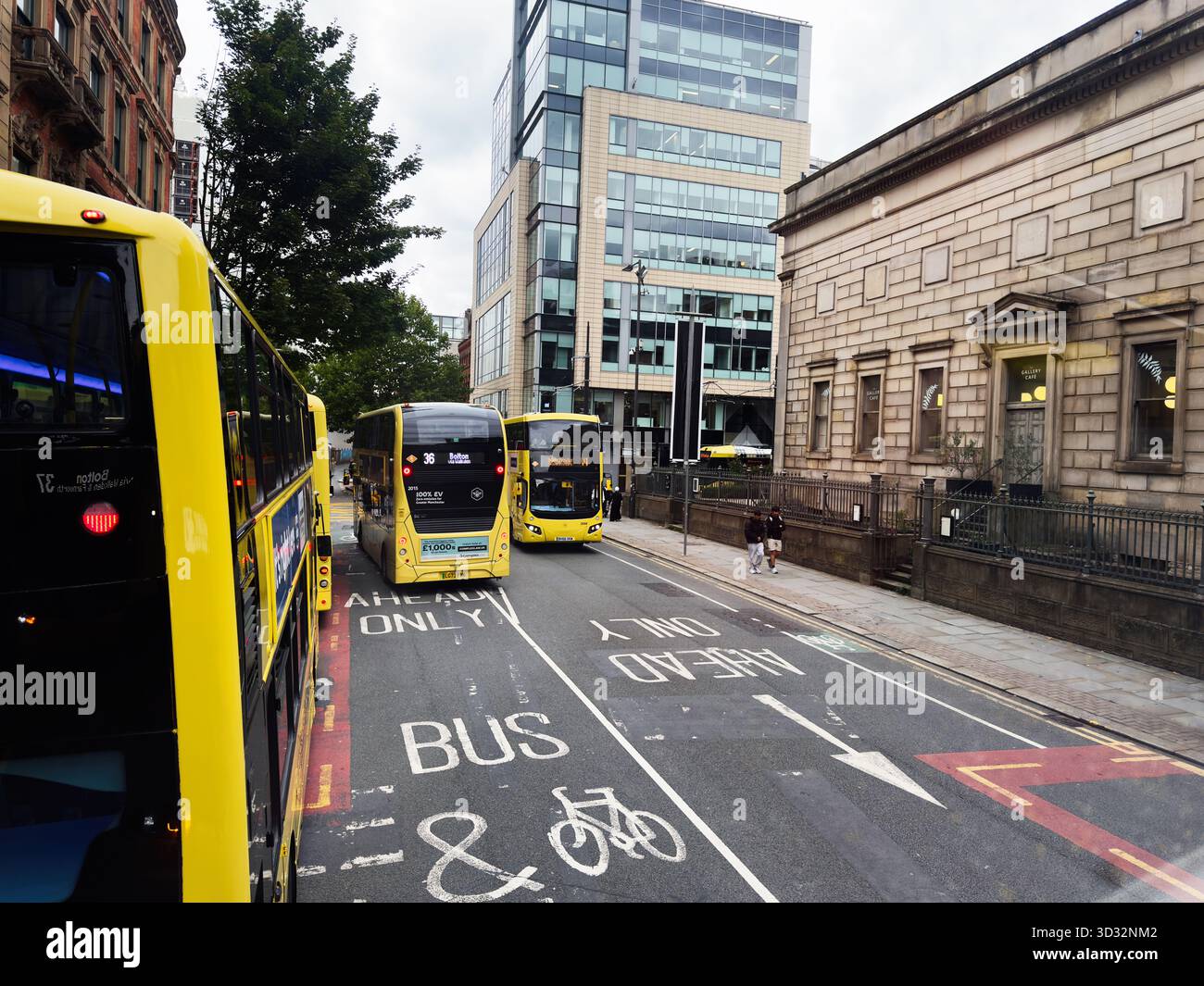 Manchester, UK - September 29, 2025: Busy Manchester street with yellow buses, pedestrians, and modern architecture. Stock Photo