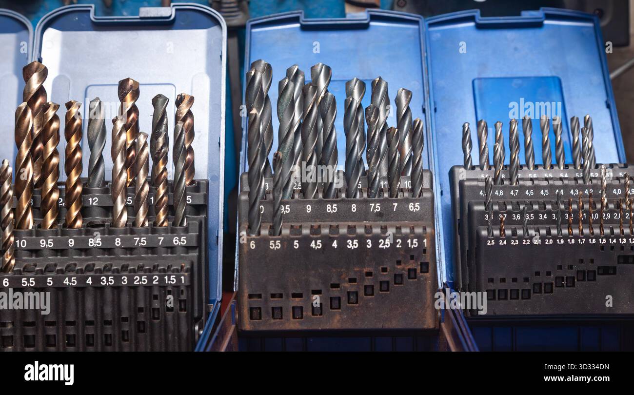 Sets of drills on a table in a workshop. Stock Photo