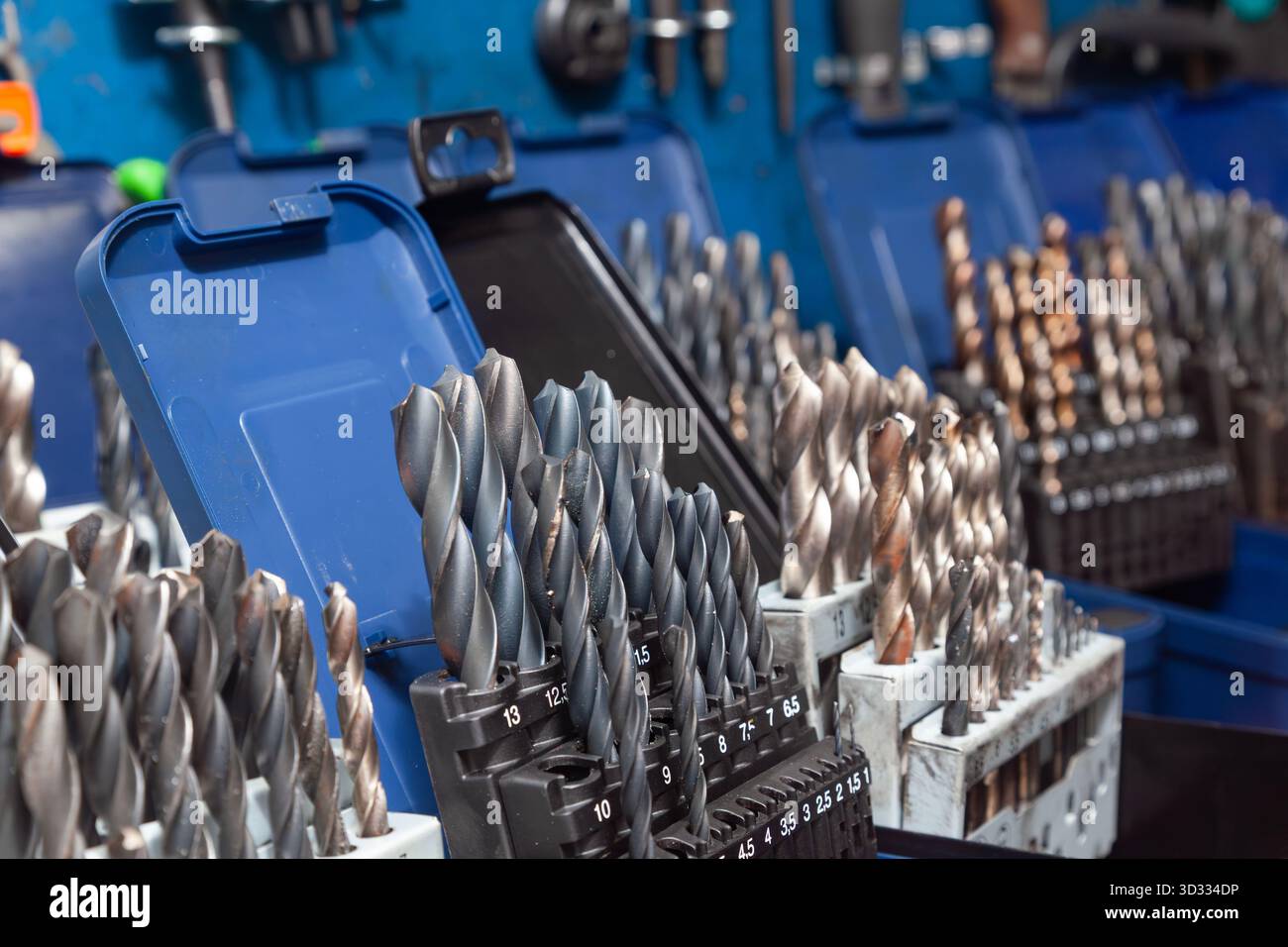 Sets of drills on a table in a workshop. Stock Photo
