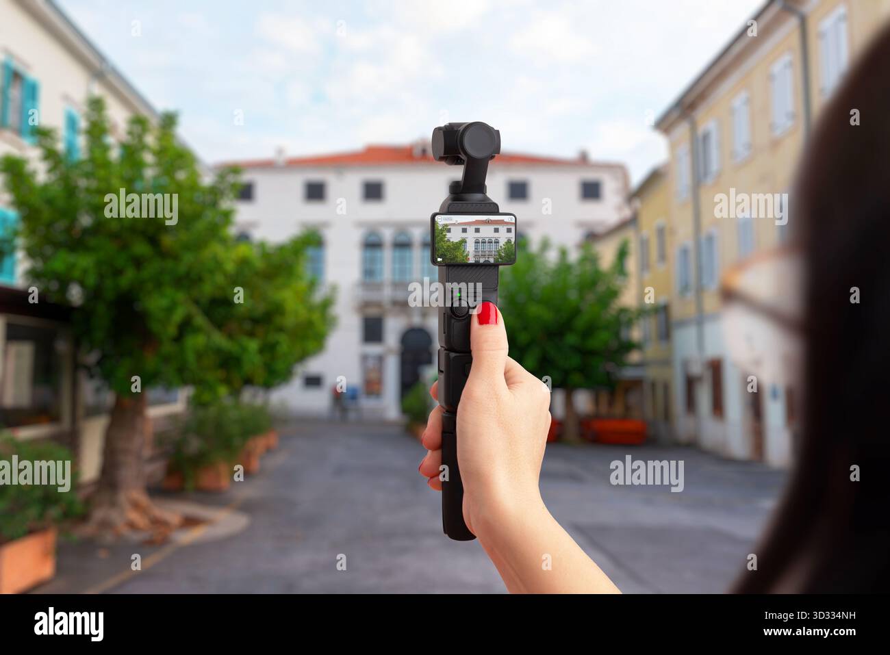 Handheld compact camera recording urban street and historic architecture, concept of travel, vlogging, tourism and creative city exploration Stock Photo