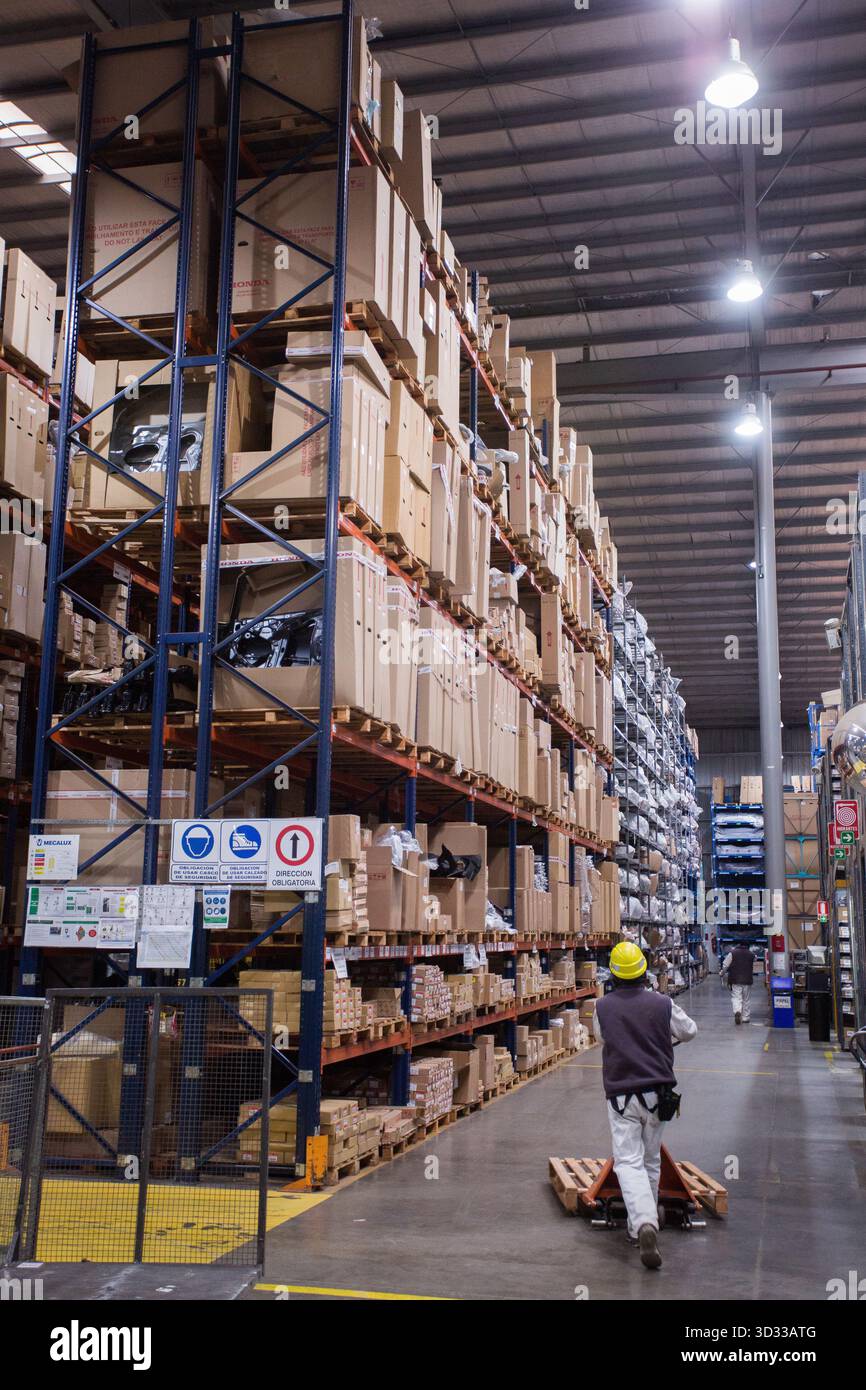 Men at work, wearing protective stuff, handling boxes in a warehouse Stock Photo