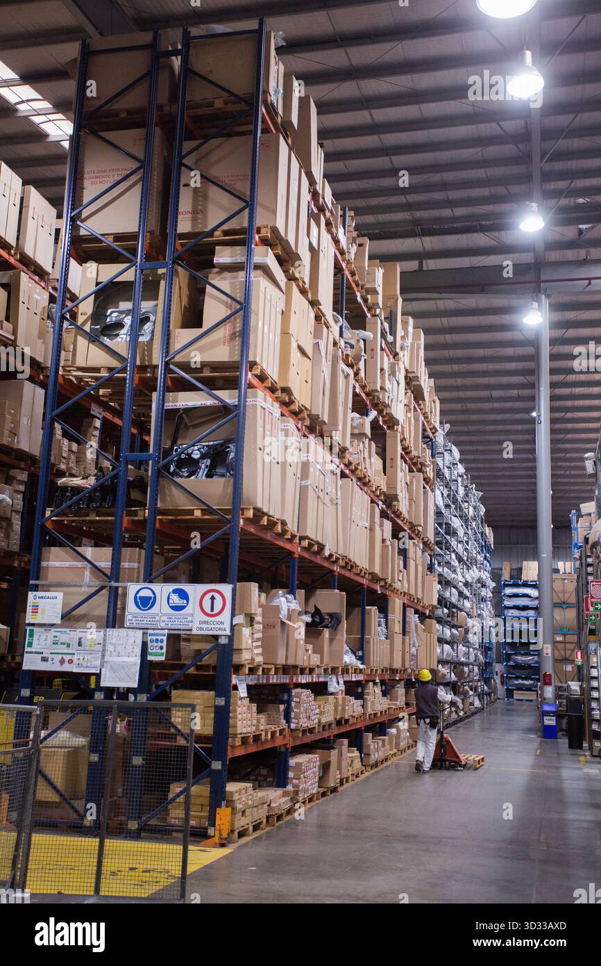 Men at work, wearing protective stuff, handling boxes in a warehouse Stock Photo