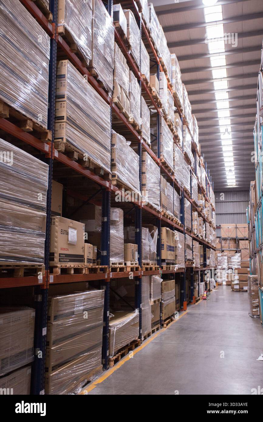 Men at work, wearing protective stuff, handling boxes in a warehouse Stock Photo