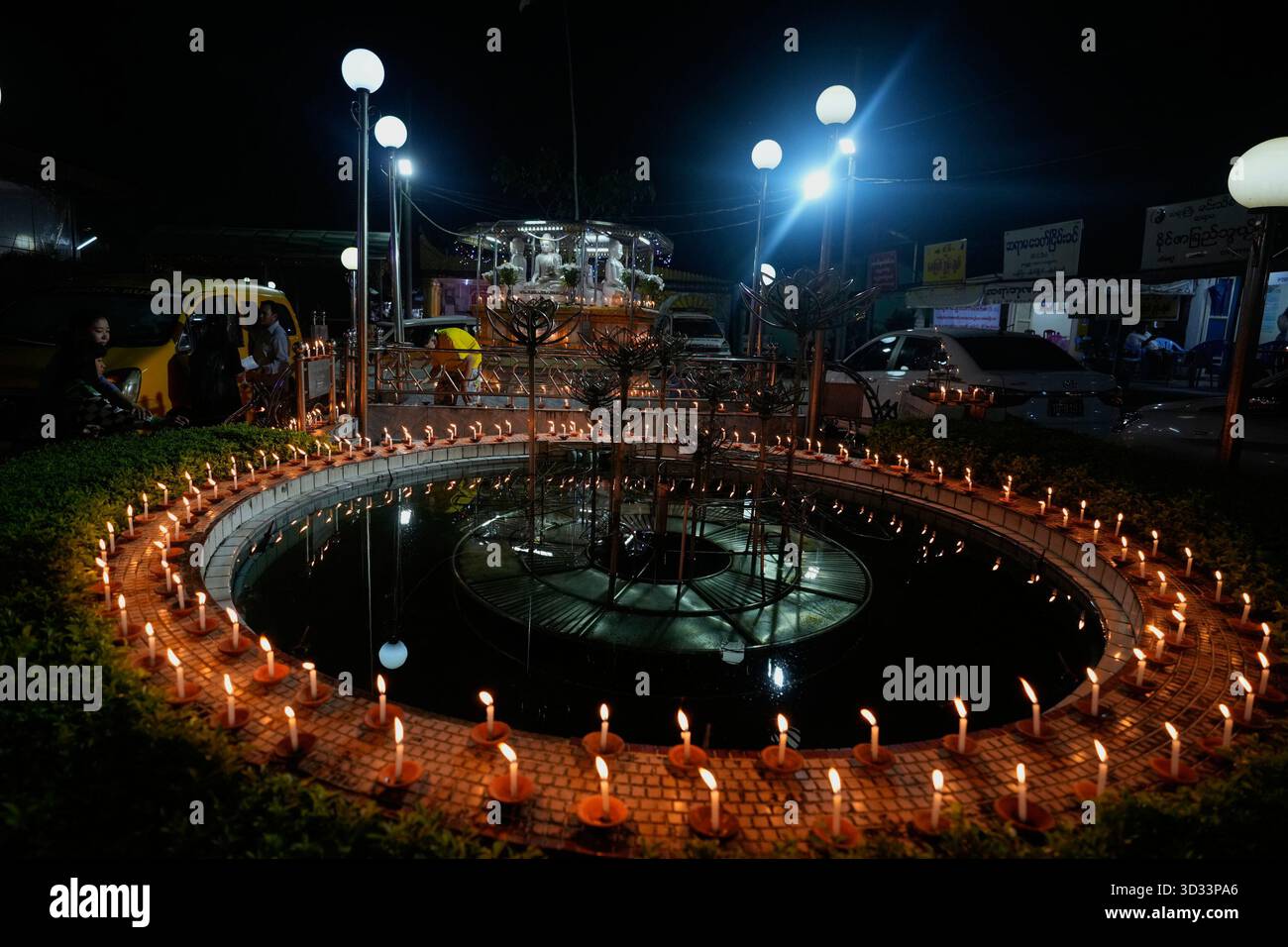 Buddhist devotees light candles during the full moon day of Tazaungmone ...