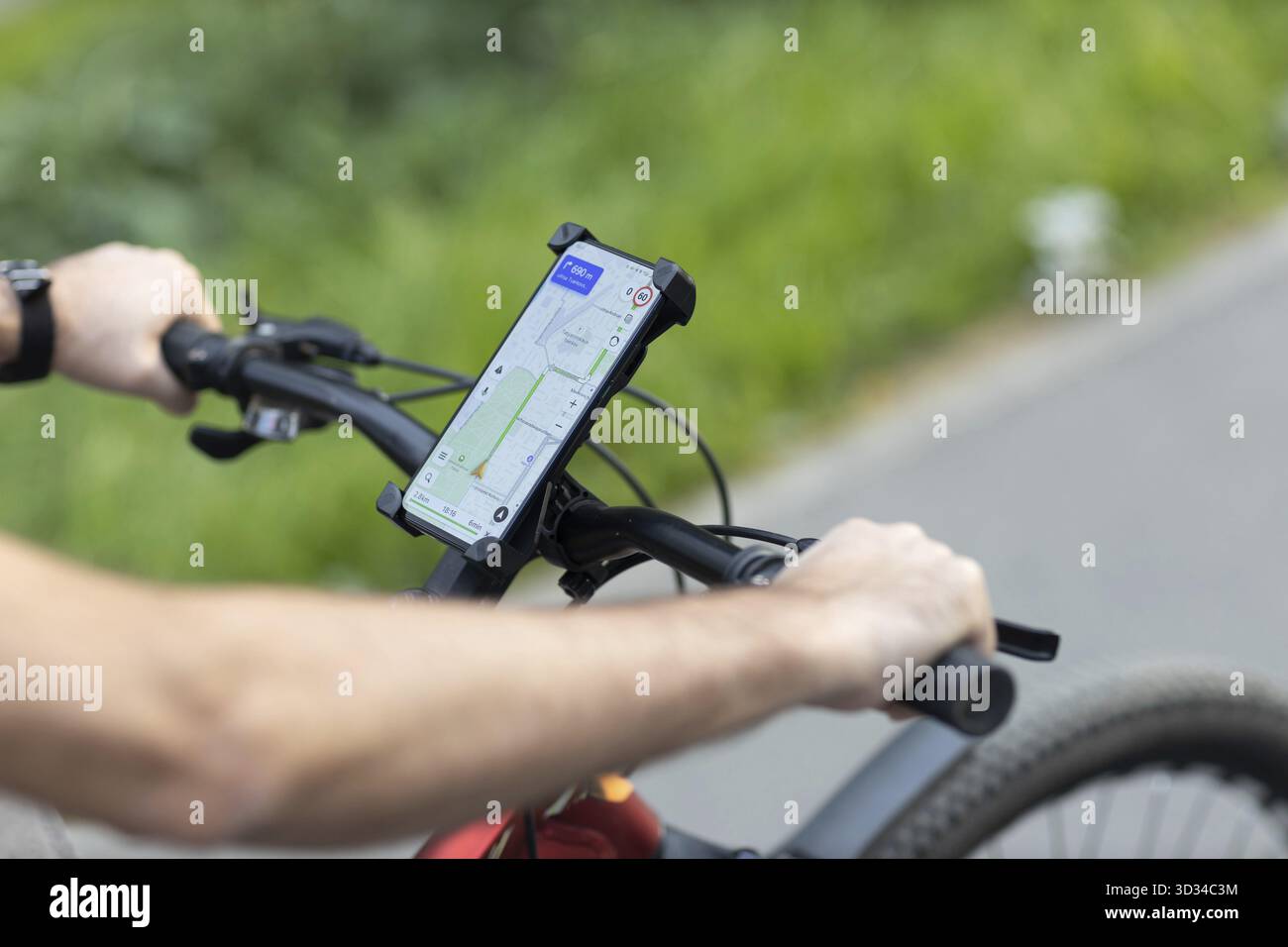 Man planning route using GPS navigation application in mobile phone on his bicycle bike Stock Photo
