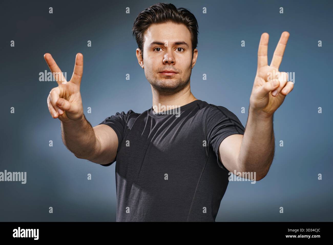 Young brunette man showing victory handsign Stock Photo