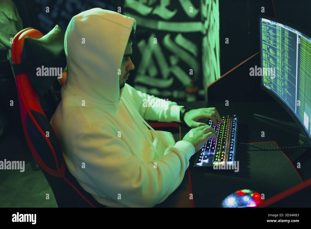 Hacker in hoodie working hacks code site on personal computer laptop Stock Photo