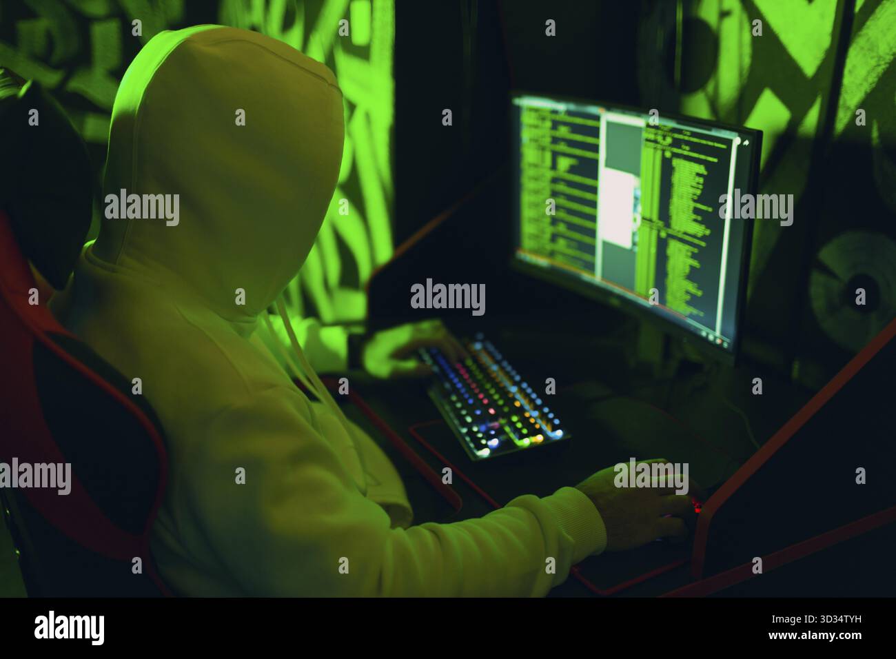 Hacker in hoodie working hacks code site on personal computer. War and cyber attack concept Stock Photo