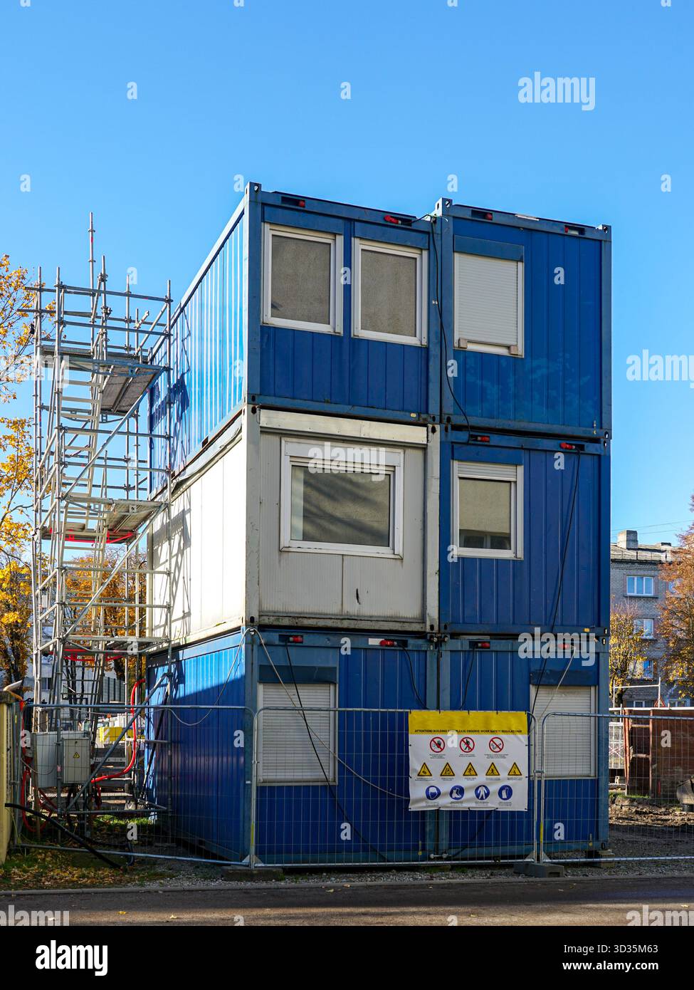 Stacked blue modular office containers at construction site with safety ...