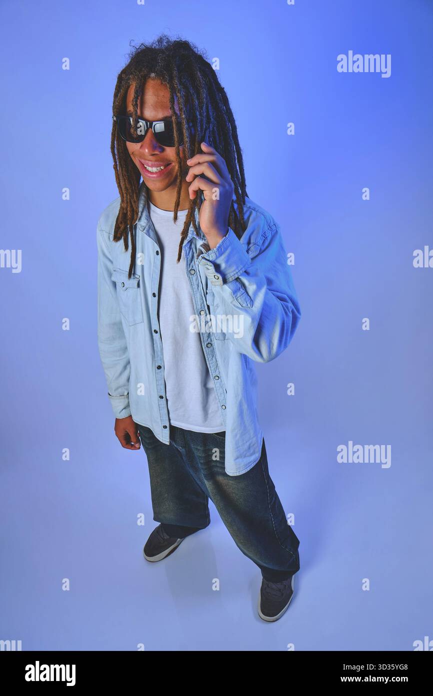Young man with dreadlocks smiling and talking on phone Stock Photo