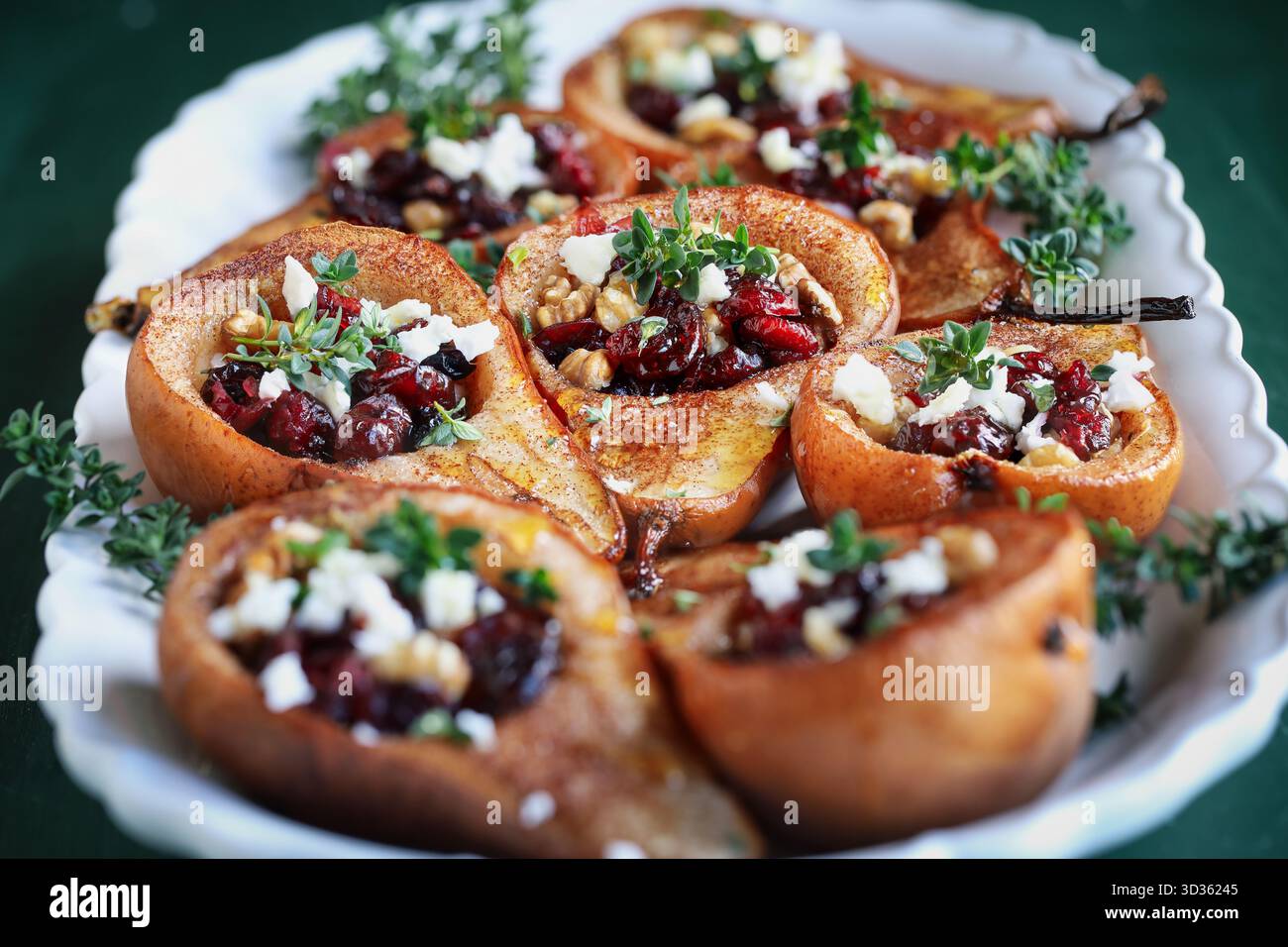 Baked pears with Feta cheese, walnuts, thyme and cranberries. . Front view. Stock Photo