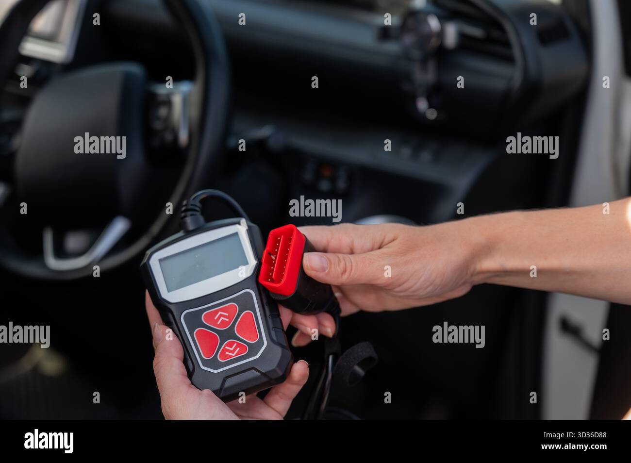 Woman using OBD2 diagnostic scanner. Stock Photo