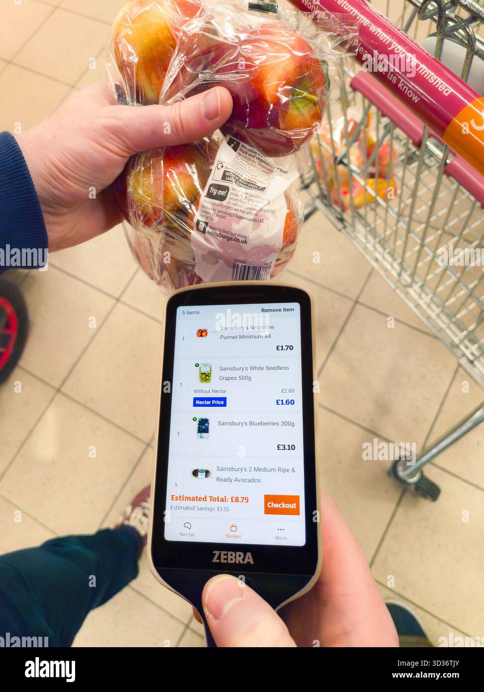Man holding a scanner for scanning product barcode for self checkout at Sainsbury supermarket, also known as scan & go, smartshop & self checkout, UK - Smartphone Captured Stock Image