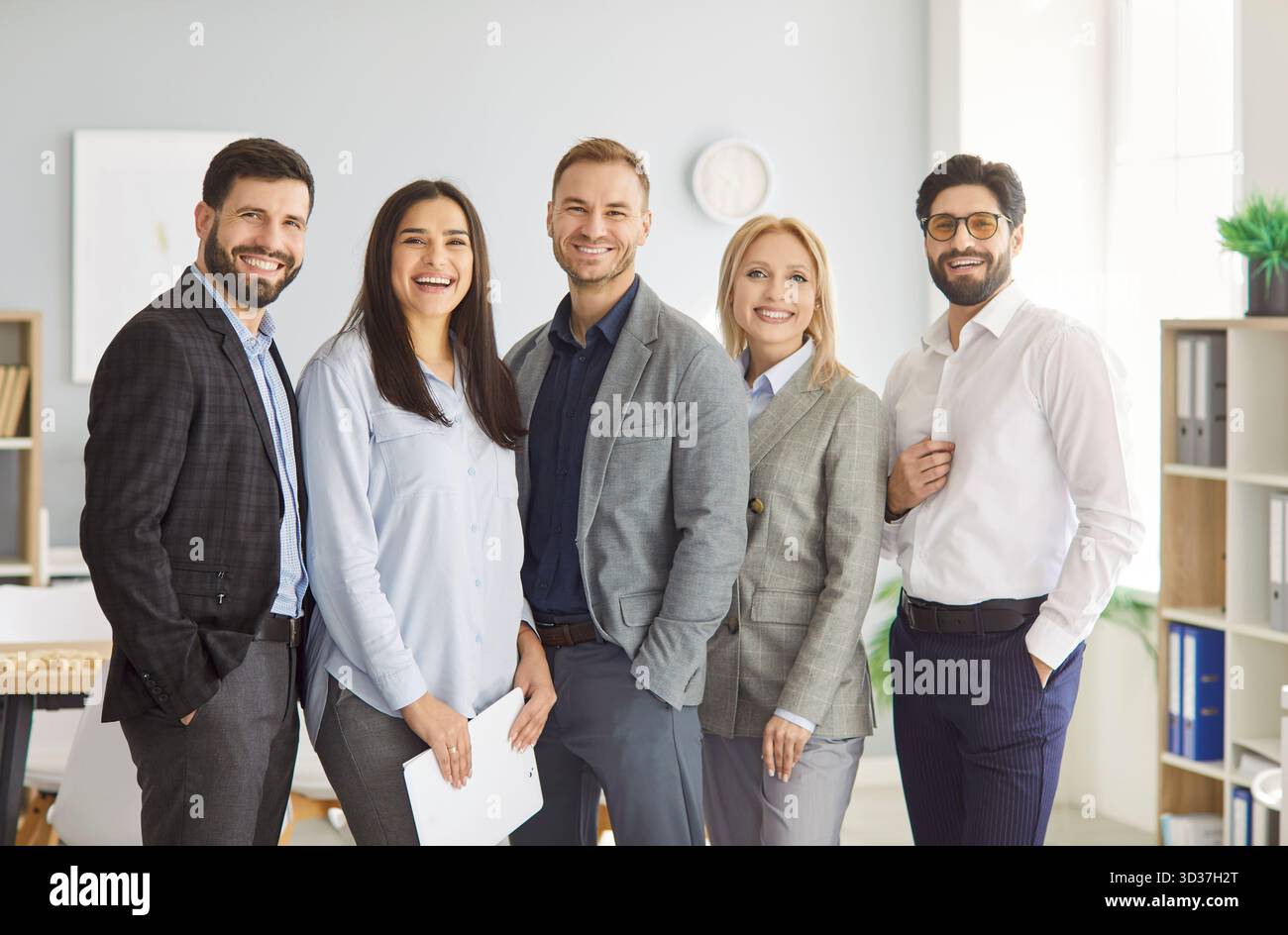 Group of successful smiling business people standing together in office ...