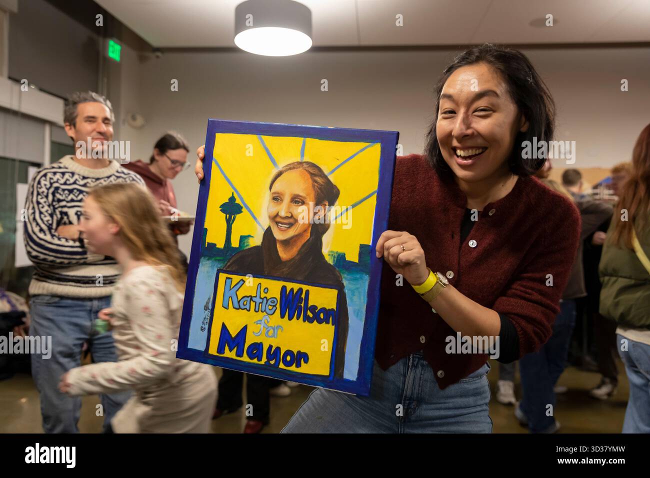 Seattle, Washington, USA. 4th November 2025. An enthusiastic supporter holds a painting of Katie Wilson during an election night party at El Centro de la Raza. Progressive candidate Katie Wilson led the incumbent Seattle mayor Bruce Harrell by a healthy margin winning an outright majority in the top-two primary. Credit: Paul Christian Gordon/Alamy Live News Stock Photo