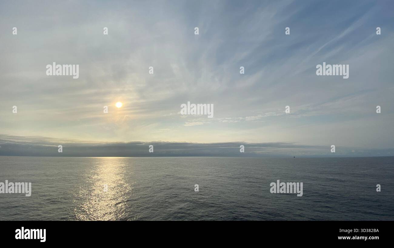 Beautiful sunrise over the ocean, with warm golden light reflecting on calm waves and a peaceful horizon. - Smartphone Captured Stock Image