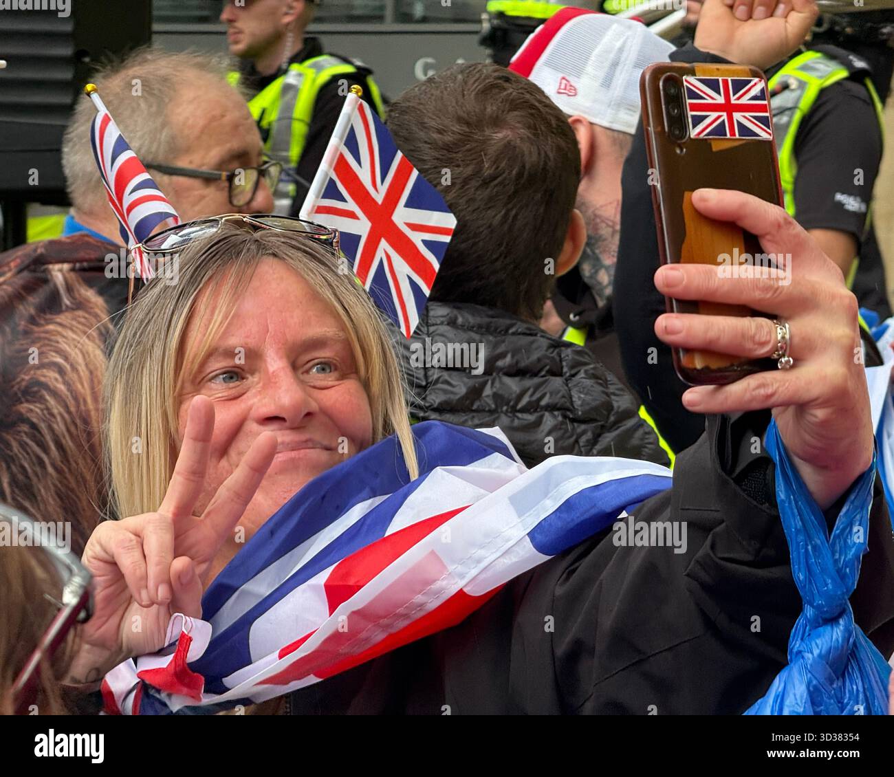 Female protestor bedecked in Union Jacks takes a selfie at the Glasgow Rises Unity Rally - Smartphone Captured Stock Image
