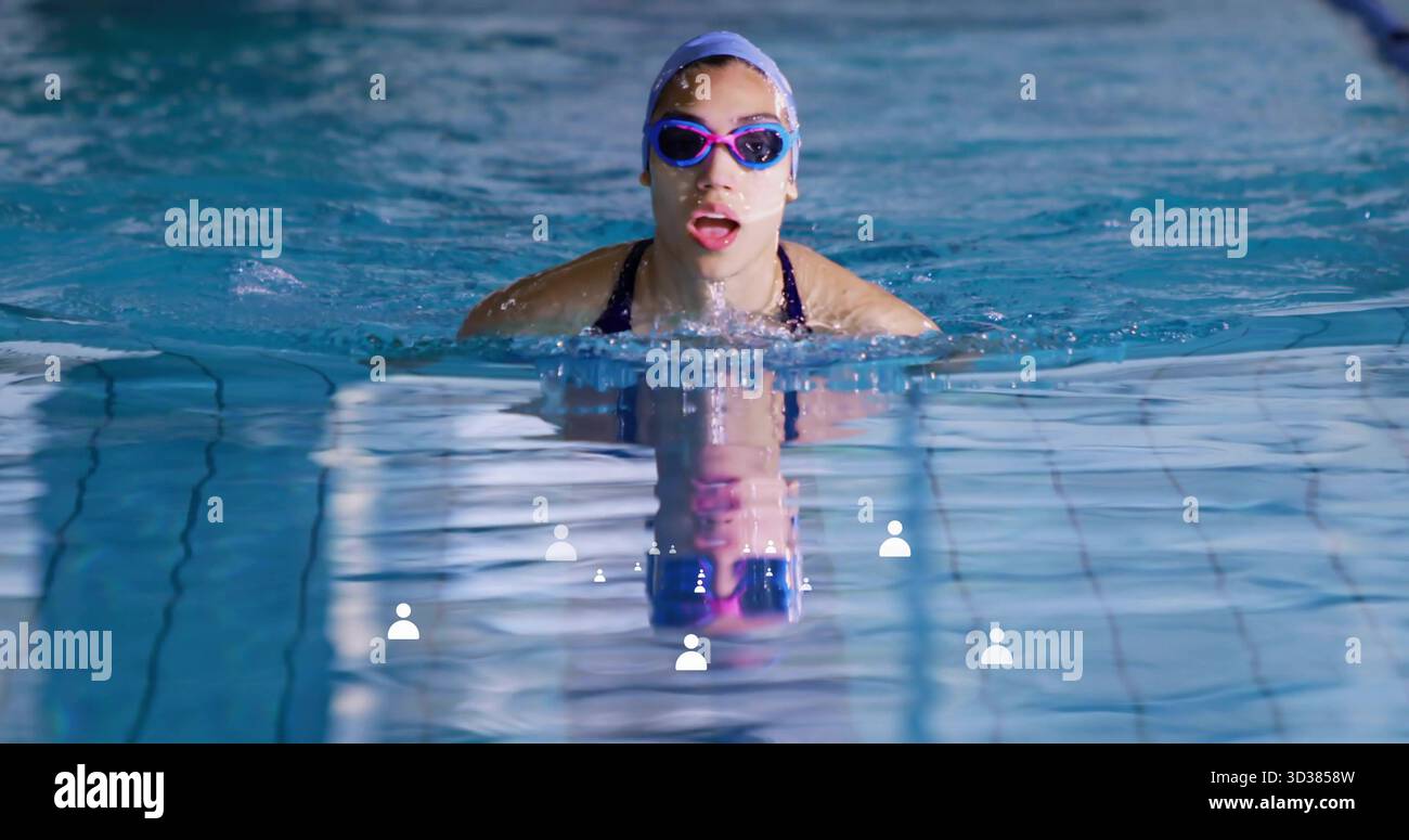 Emerging woman doing breaststroke at pool with swim cap goggles ...