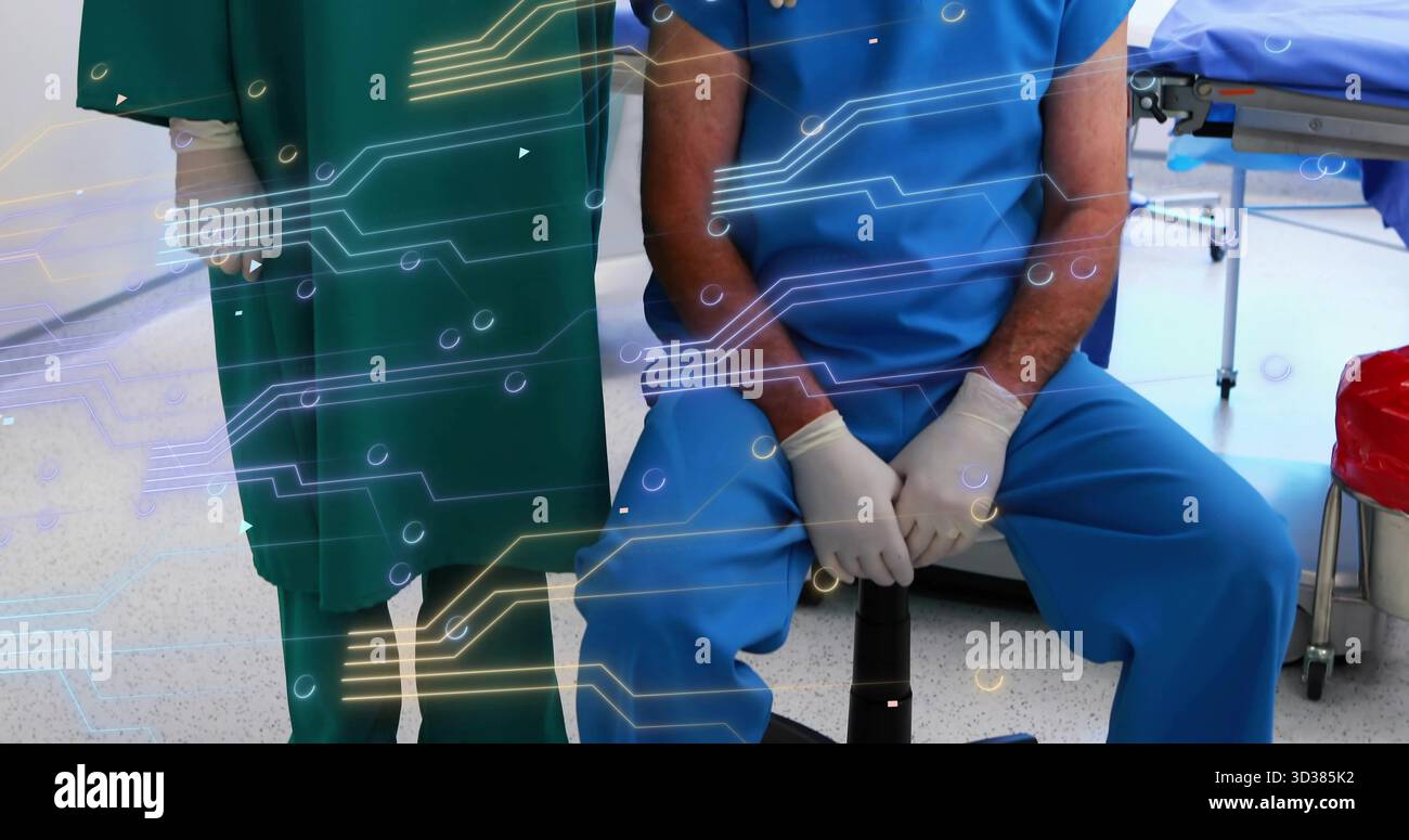 Team in scrubs monitoring circuit overlay in treatment room, with ...
