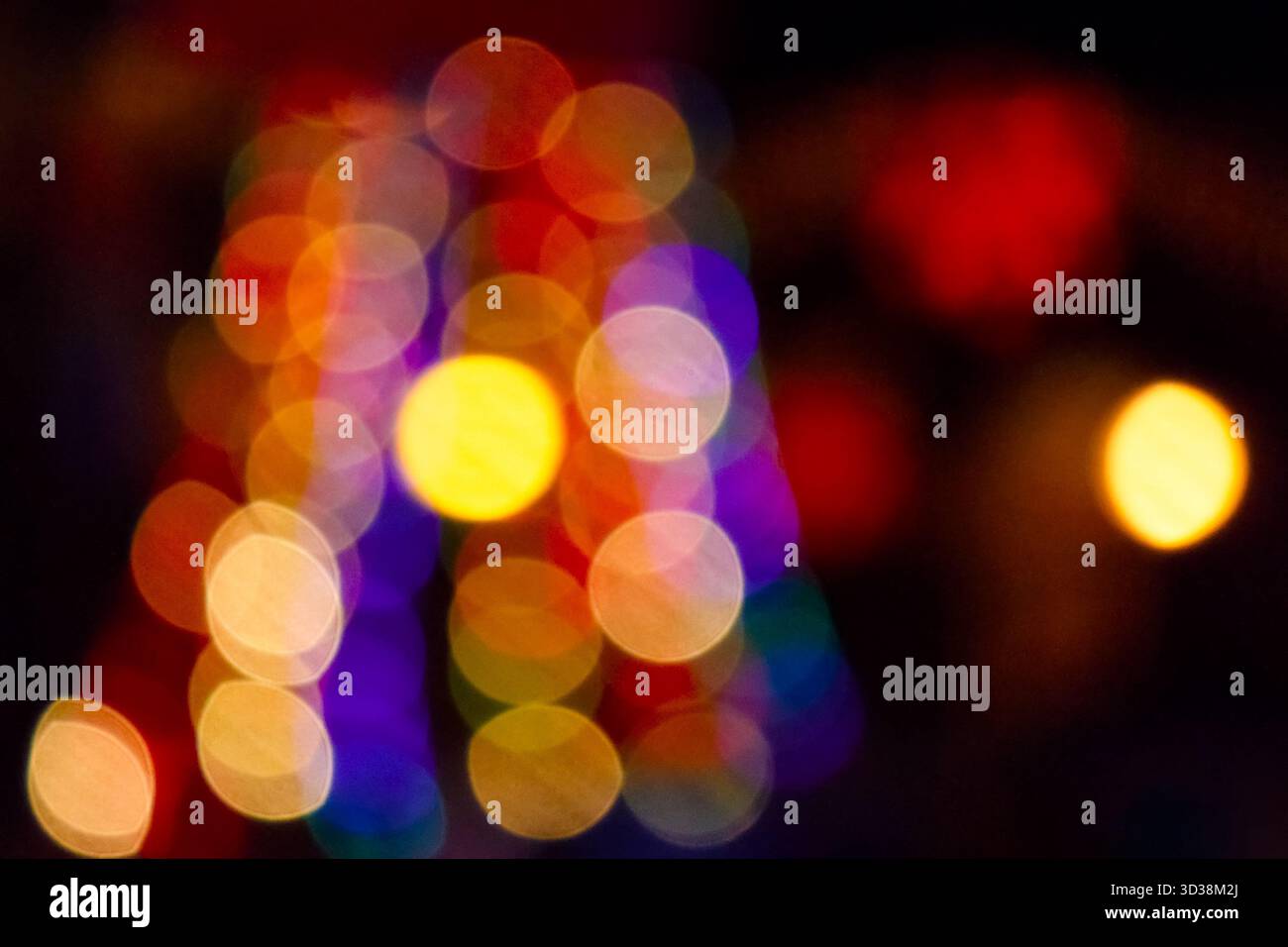 winter holiday colorful bokeh. festive decorated christmas tree lights on city street for beautiful new year abstract background. defocused red and ye Stock Photo