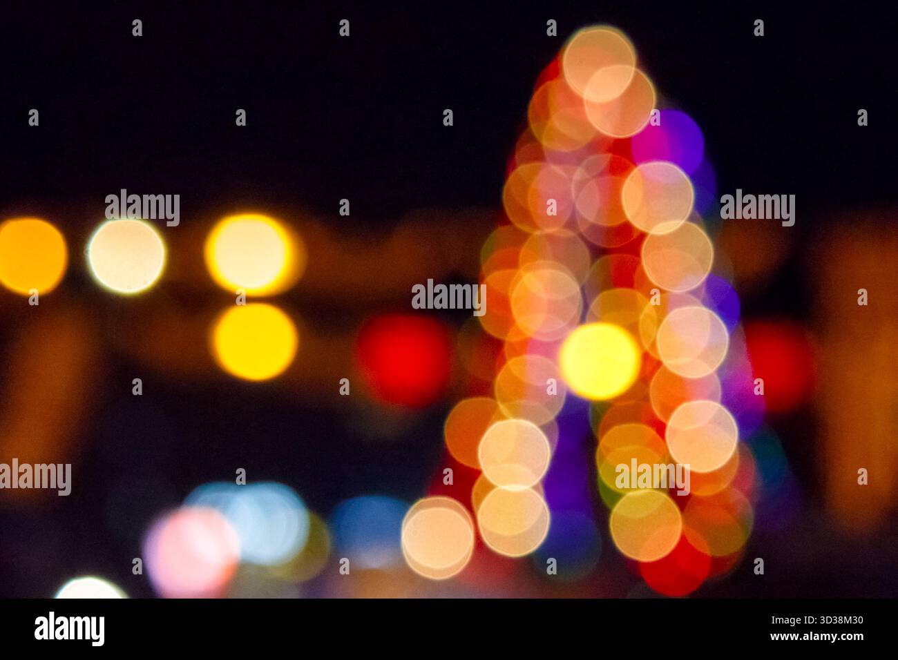 winter holiday colorful bokeh. festive decorated christmas tree lights on city street for beautiful new year abstract background. defocused red and ye Stock Photo