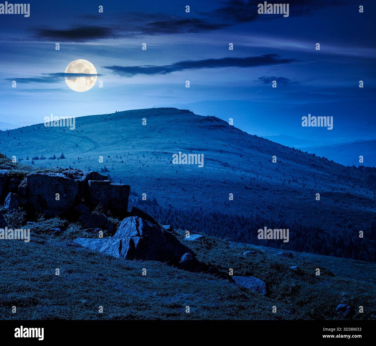 alpine meadows in mountains in summer at night. stones on grassy hills in full moon light. popular travel destination for photo. background for invest Stock Photo