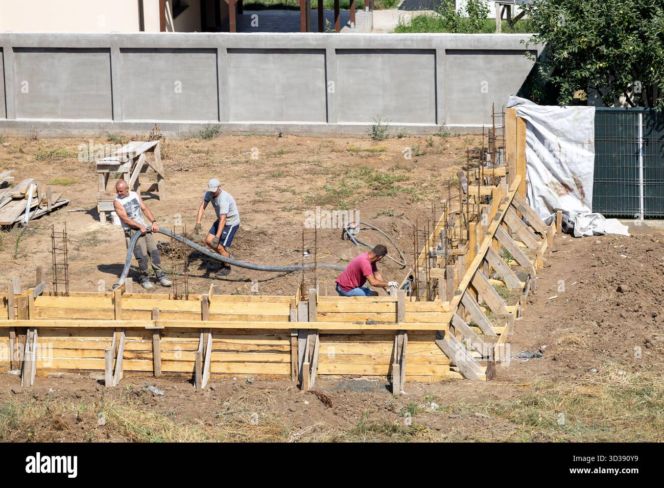 Construction crew building a new concrete fence on private property ...