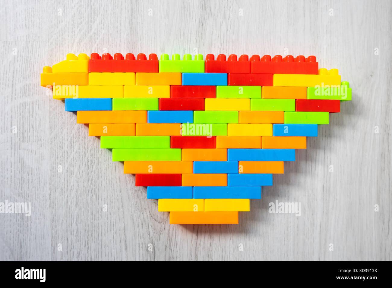 Assembled multi-colored plastic construction blocks lie on the floor. Stock Photo